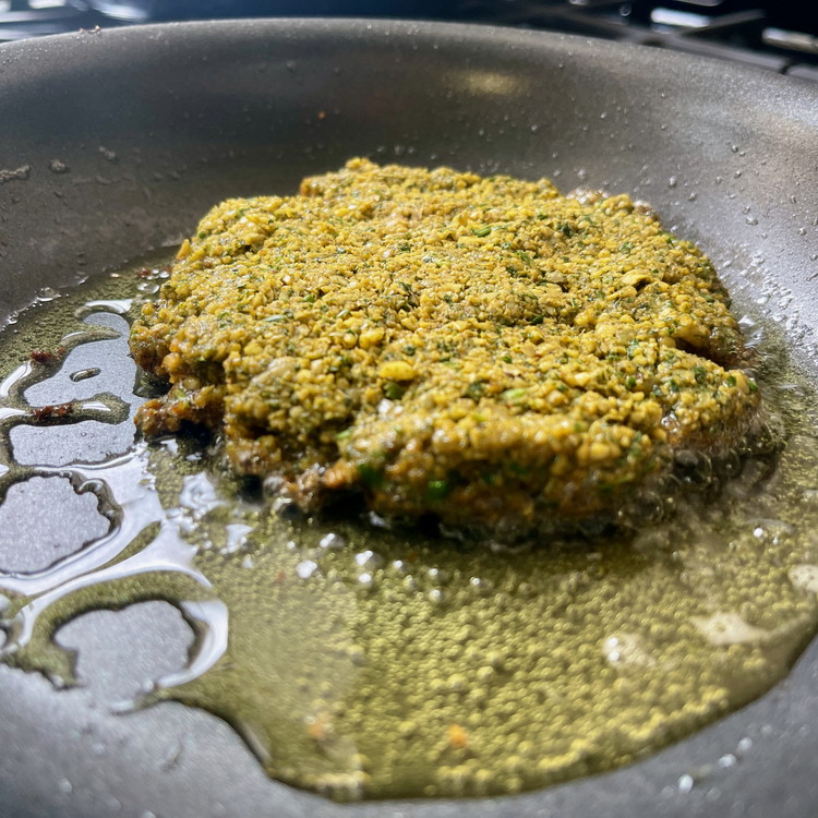 Image of Carefully slide each burger into the heated oil and let them simmer in the oil until golden brown and crunchy.